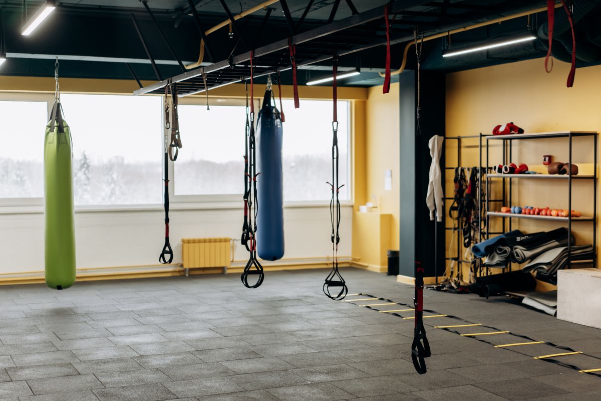 A bright modern home gym room with weights, mats and mirrors