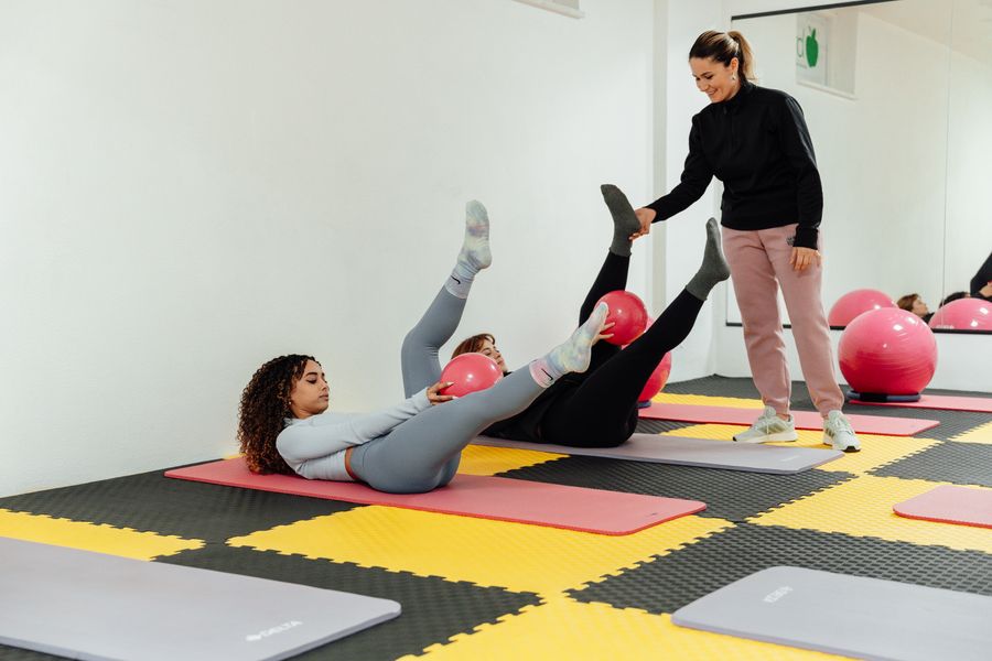 Participants stretching on exercise mats and stability balls during a class